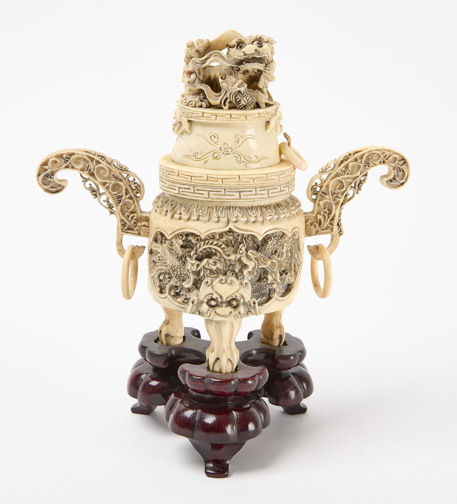 Chinese Carved Bone Covered Urn: Covered urn featuring a foo dog atop the cover. Carved bone mounted on a wood base. Chinese. H 8-3/4" W 7-1/2" D 3-5/8" Condition: Good antique condition. Small top ring which has separ
