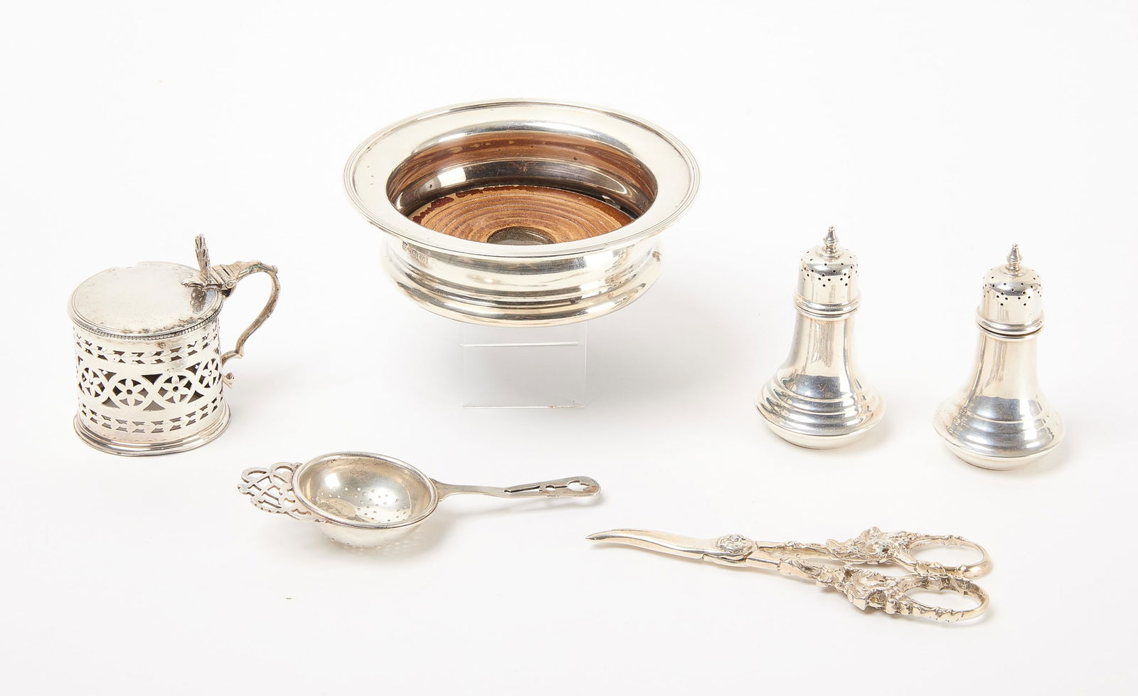Antique Silver Group: Antique silver group including grape shears, wine coaster, tea strainer, salt and pepper and a mustard. Silver, 11.3 ozt. plus wine coaster. Grape shears: L 6" Wine coaster: H 1-3/4" D 5-3/4