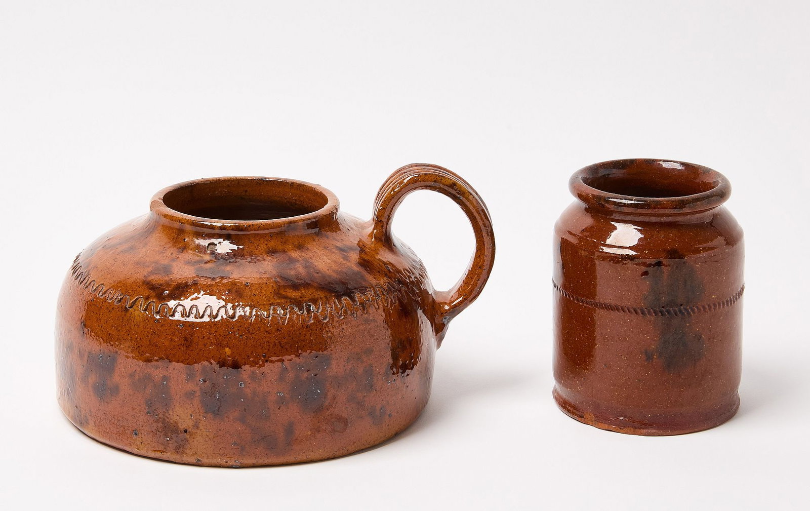 Redware Jar and Bean Pot: Glazed redware jar and bean pot. Pennsylvania. Mid 19th century. Jar: H 5" D 4". Bean pot: H 5-1/4" D 8". Condition: Bean pot missing lid, some roughness to base of jar. 