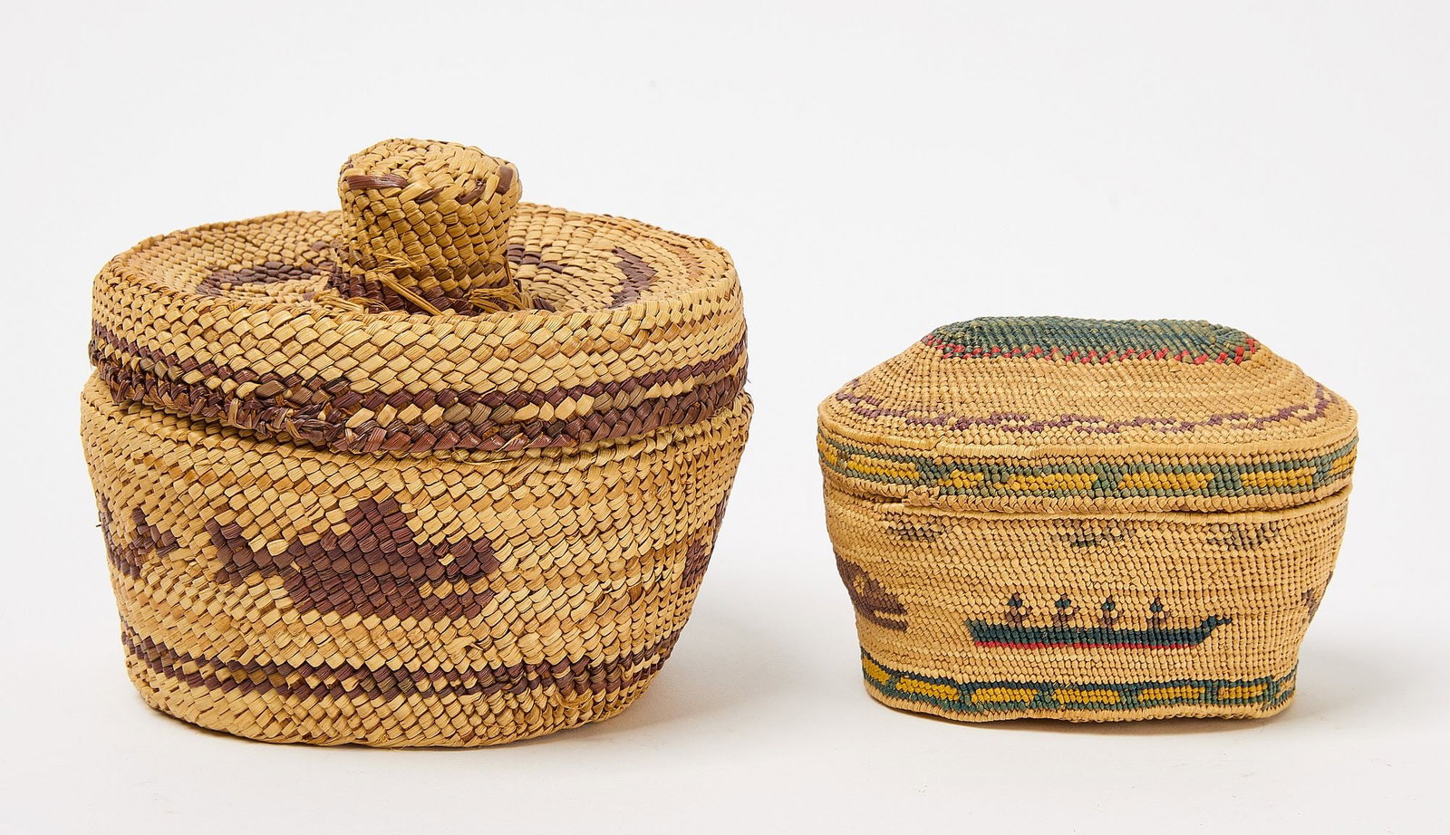 Two Native American North-West Coast Baskets: Two Native American lidded baskets. One round with rattle top lid and boat and whale design in purple tones. The smaller; Tlingit oblong basket with dome top and decorated in whale hunting scenes in h