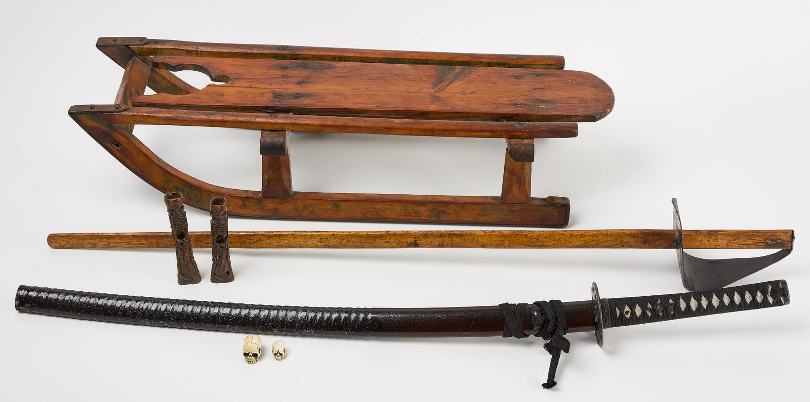 Sled, Swords, and Netsuke Style Skulls: Sled, wwords, and skulls. An interesting and slightly edgy collection to include: a small 19th century wood and iron sled. Some evidence of old green paint. Iron ring for hanging. Solid. Tw