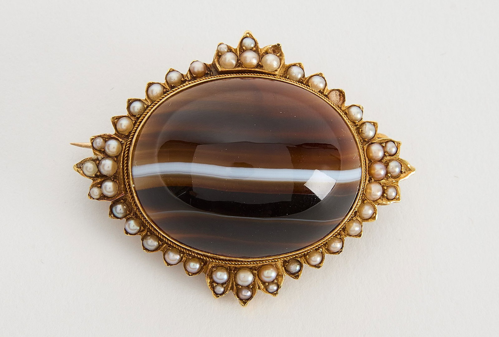 Victorian Banded Agate Brooch-Locket Combination: Victorian memoral banded agate cabochon with seed pearls. 18kt (acid tested) Agate carved on inside, exibition back, original closures/clasps, 12.3 dwt Provenance: Lang Antiques, SanFranci