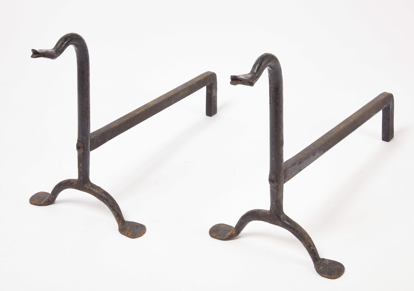 Pair of Snake Andirons: Pair of snake andirons with penny feet. Black paint over wrought iron. American, 19th century. H 16-1/2" W 11" L 25-1/4". Condition: Uniform surface wear.