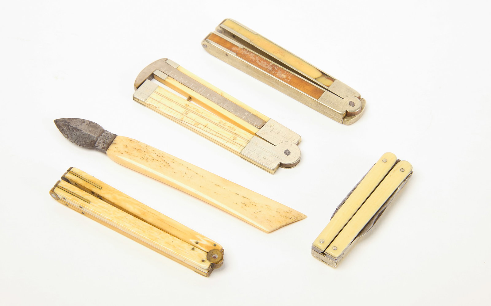 Bone Rulers, Scissors, and Ink Scraper: Three folding bone rulers, folding bone scissors, and an ink scraper with bone handle. 19th century. Condition: Minor imperfections. Ink scraper with loss to top of handle. 