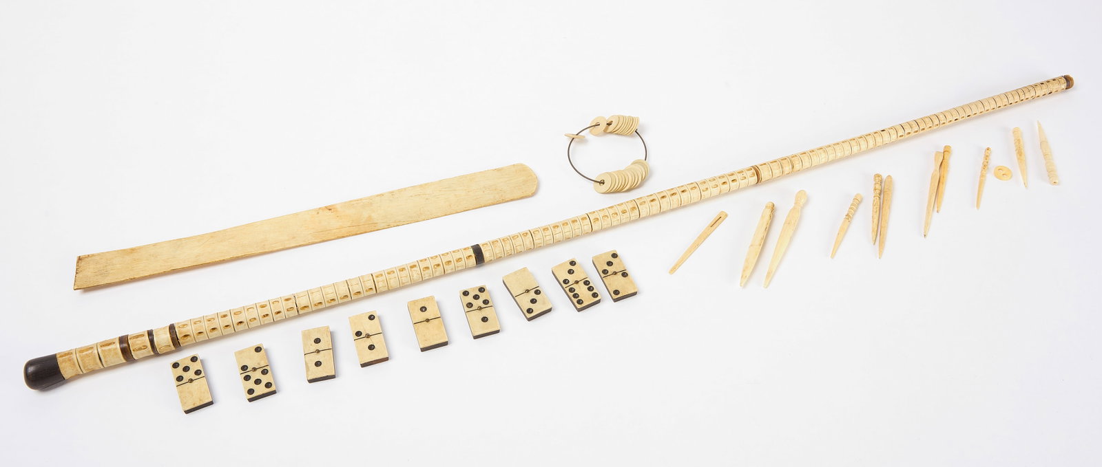 Whaling Nautical Group: Nautical and whaling group. Including a shark vertebrae walking stick, whale bone busk, whalebone and ebony dominoes, bone washers, and several sewing implements. American, 19th century. Busk: L 