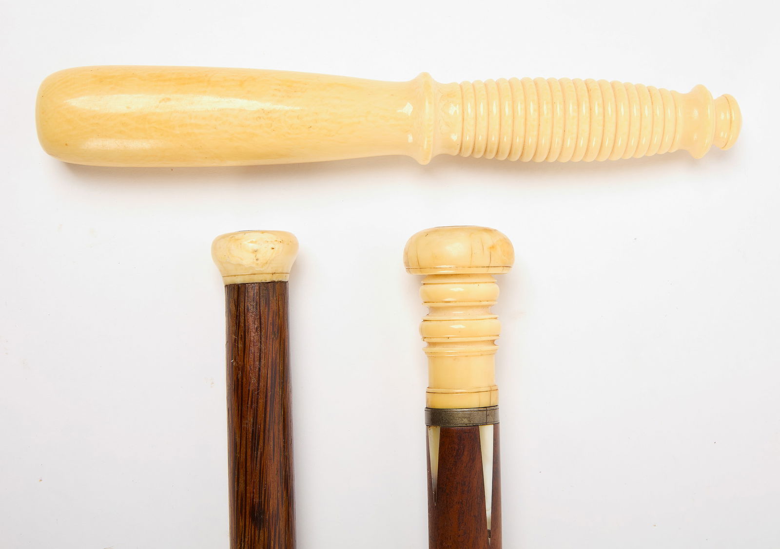 Bone Walking Stick, Baton, and Billy Club: Maritime related group. Including a cane with bone knob and inlaid mother of pearl. A bone club. An exotic wood baton with bone knob caps. American, 19th century. Cane: L 34-1/8". Club: L 9-