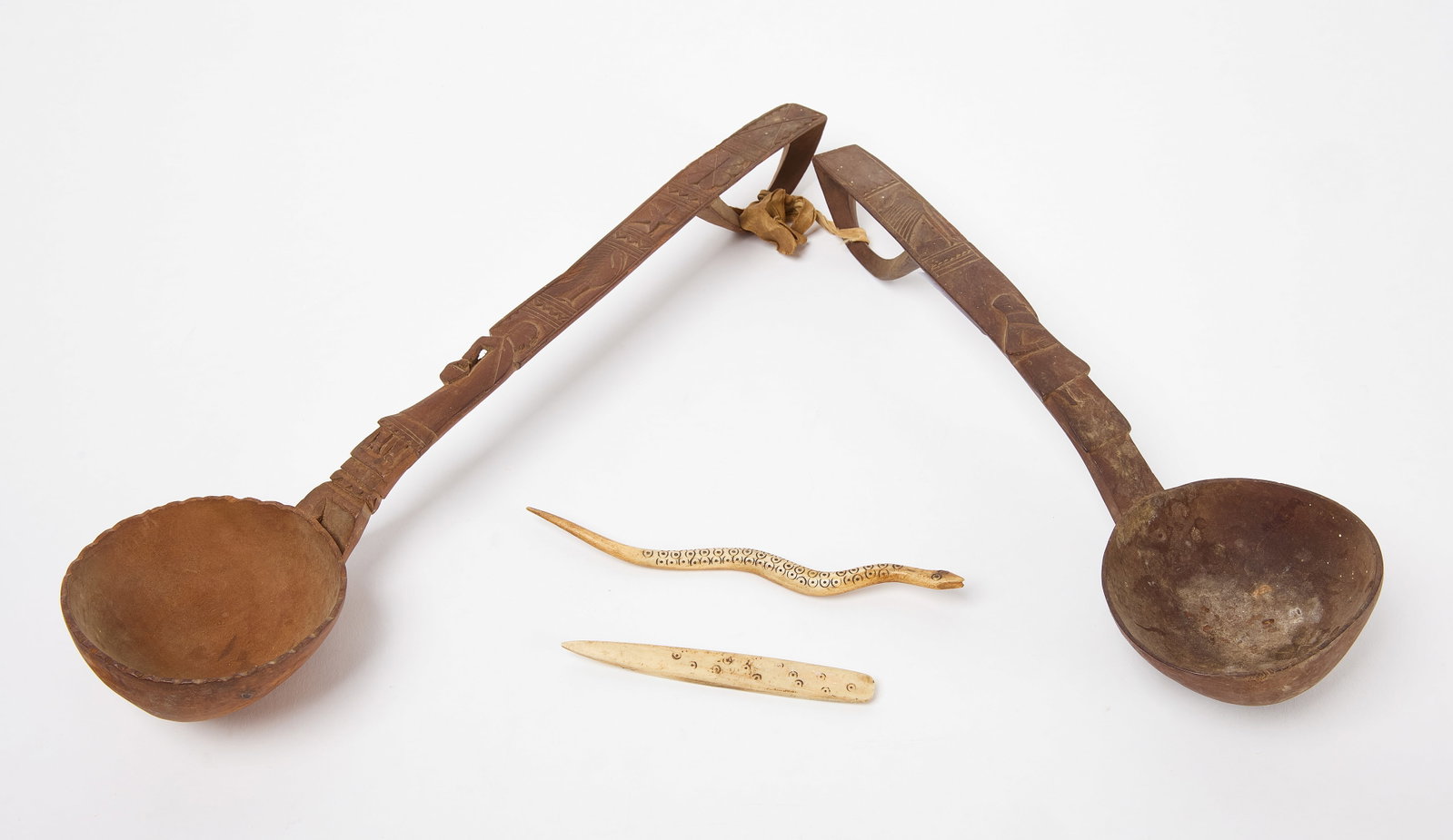 Two French Prisoner of War Whimseys Together with Wooden Spoons: Two prisoner of war whimseys. One a snake, the second an awl. Carved bone. French, early to mid-19th century. Together with spoons. Carved wood. Probably French, mid-19th century. Snake: L 7".&nb