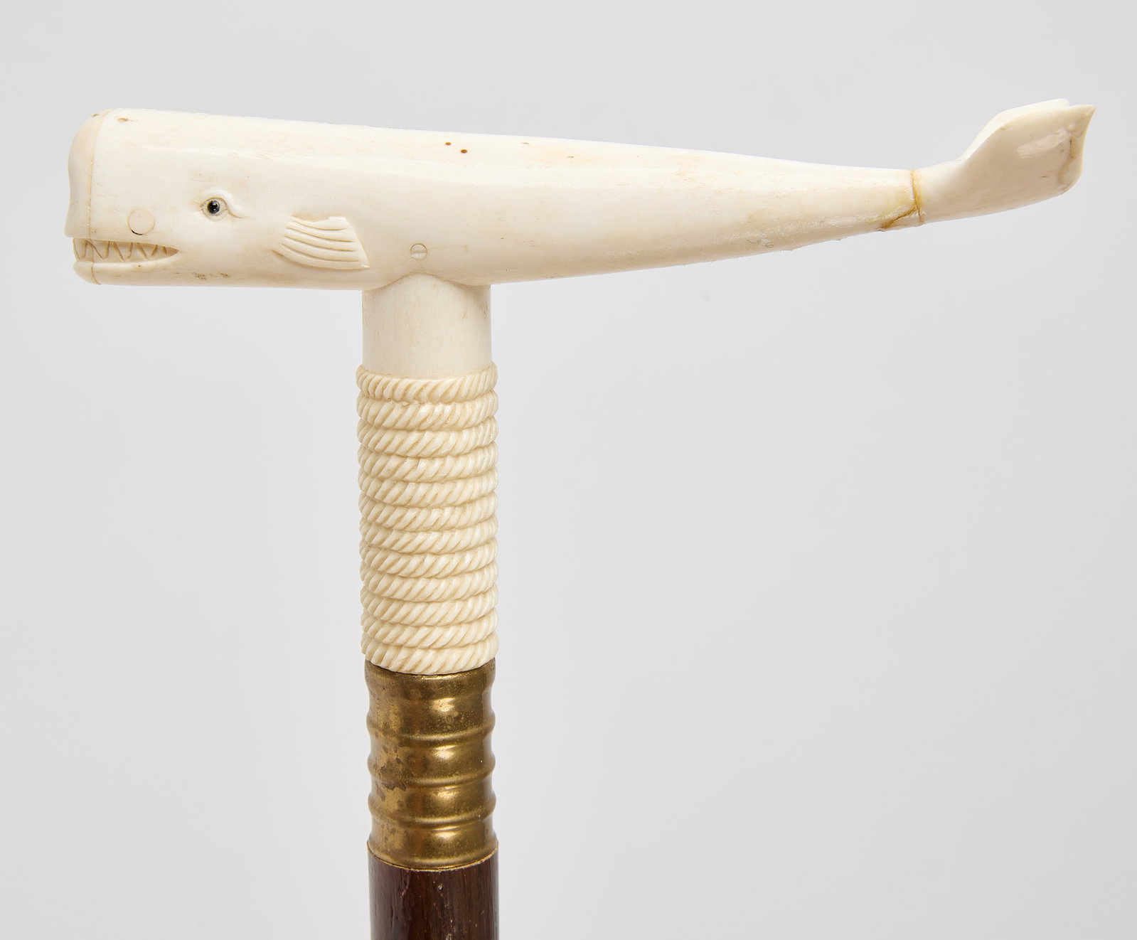 Sailor-Made Walking Stick with Carved Whale Handle: Sailor-made walking stick with handle in the shape of a whale. Wood and carved bone. American, circa 1900. Overall: L 35". Whale: L 5-1/4". Condition: Handle with repair to whale's 