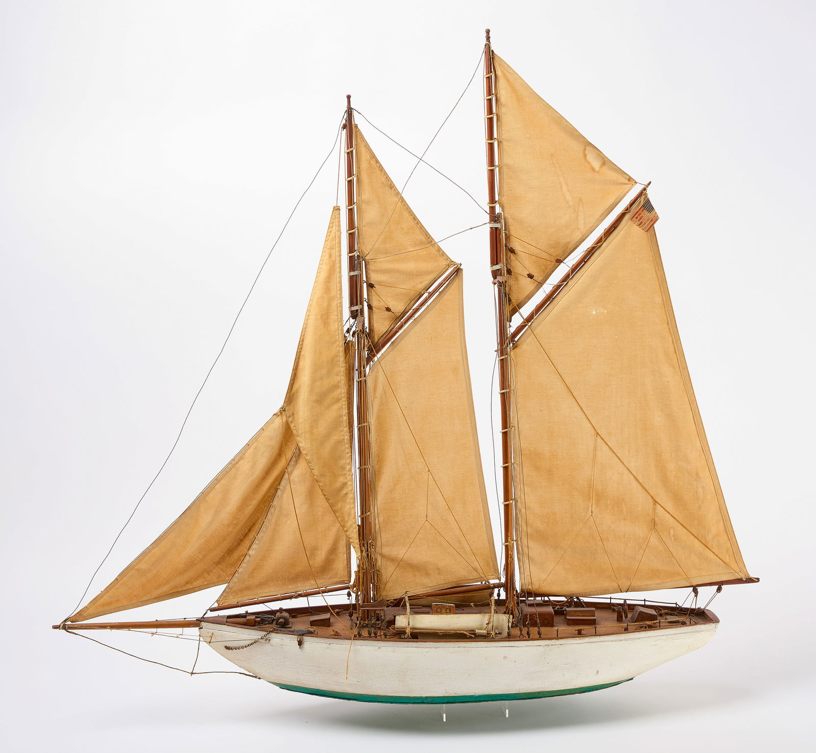 Waterline Schooner Ship Model: Ship model of a waterline schooner. Flying a 48-star flag. Wood with canvas sails. American, circa 1910. H 37-1/4" L 40-1/2" W 9". Condition: Appears complete. Some looseness to lines a
