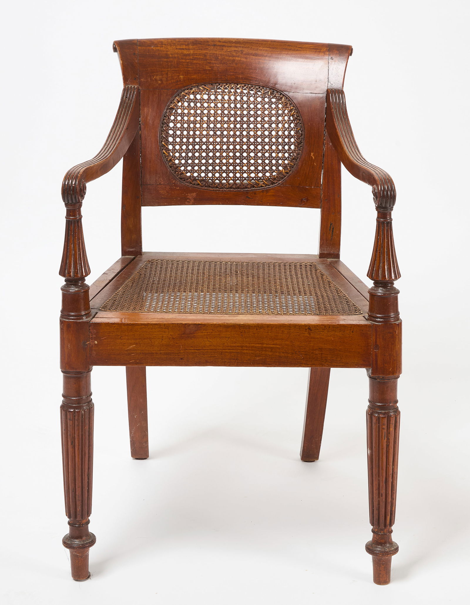 Rosewood and Rattan Armchair: Anglo Indian, ca. 1810-20, rosewood and rattan armchair. A Square back with a circular caned panel, scrolling top rail, reeded arms with scrolling ends and turned and reeded front legs. H 32 in. W 21-