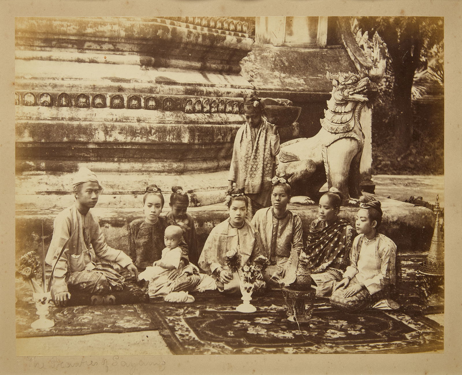 Felice Beato- Albumen Print Photograph of Figures Visiting a Burmese Buddhist Shrine: Felice Beato (1832-1909), Rangoon, ca. 1886, albumen print photograph of figures visiting a Burmese Buddhist shrine, framed. Figures seated at the base of a stupa, flanked by a carved stone guardian f
