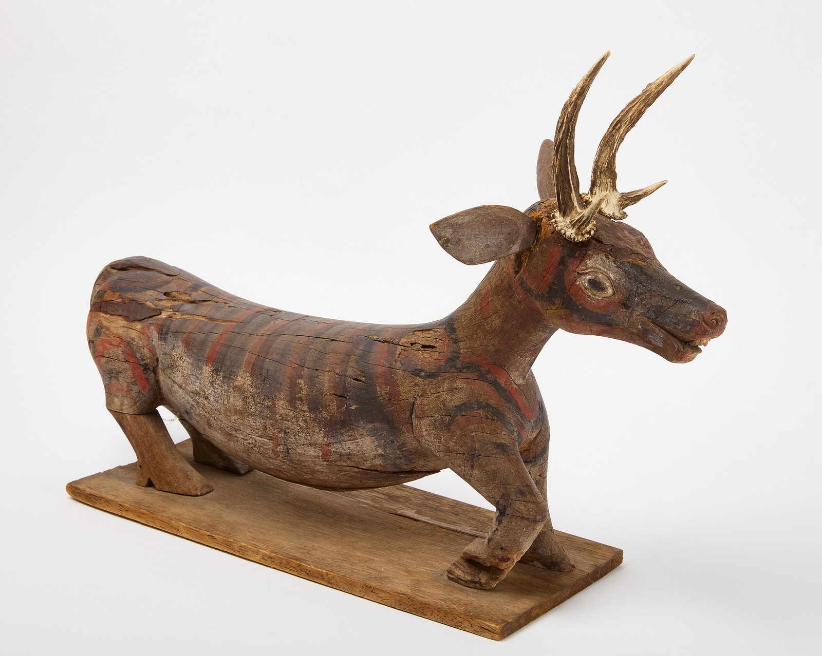 Carved and Painted Balinese Deer: Balinese or Southeast Asian carved and painted deer. Real antlers fixed to head. 19th century. H 19-1/4" L 19" W 8-3/8". Condition: Surface wear, areas of paint loss. Link to hi-res ima