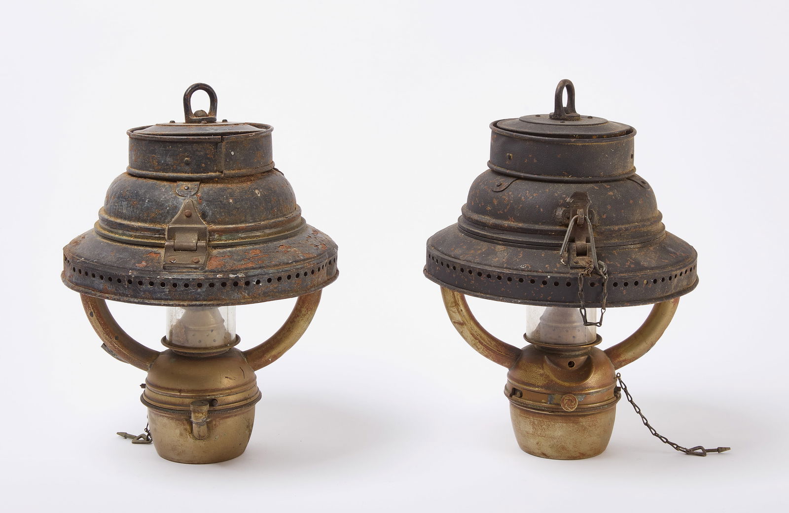 Pair of Metal Hanging Lanterns: Pair of hanging oil lamps. Old weathered paint. Circa 1900. H 14 in. W 10-1/2 in. Collection of Richard Kazarian. Condition: One has a broken chimney. Appear unmarked. Link for high-r