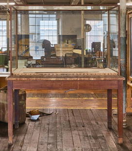 Museum Display Case: Museum display case. Wood and glass, circa 1920. H 76 in. W 65 in. D 35 in. Condition: Wear from age as expected. Slight damage to top wooden border surrounding glass.