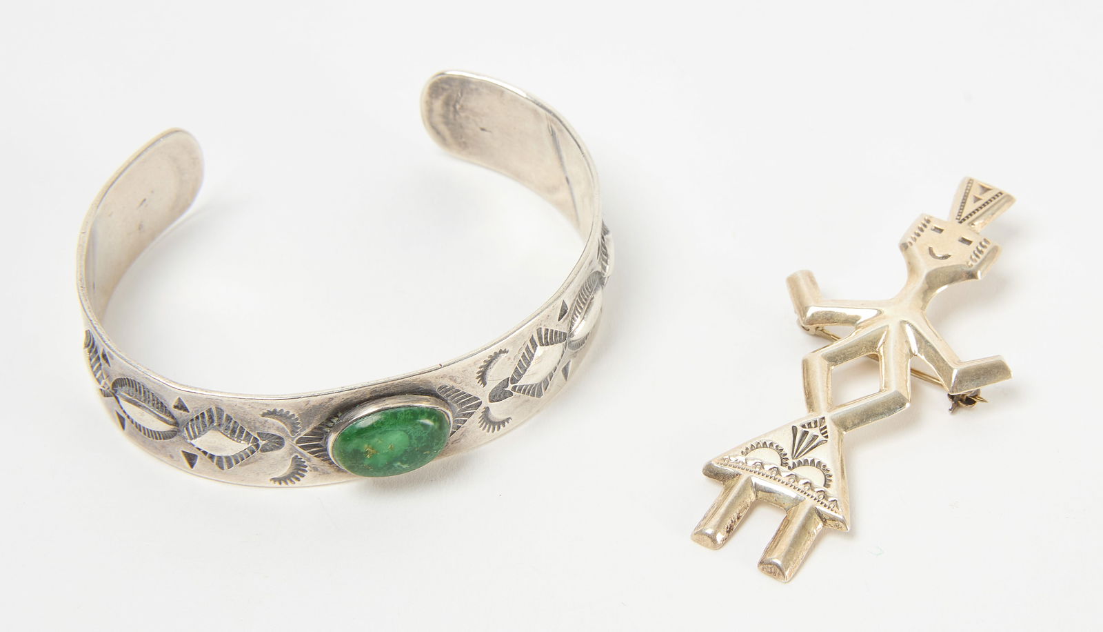 Native Bracelet and Brooch: Native bangle and brooch. Bangle has center stone. Brooch is signed 'FJ' and stamped sterling. U.S, 20th century. Bangle: D 2-1/2 in. Brooch: H 2-1/2 in. W 1 in. Total W