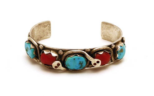 Effie Calavaza - Zuni Bangle: Effie Calavaza (1927 - 2019), Zuni bangle bracelet. Bracelet is silver and shows snakes intertwined with turquoise and red coral stones. Effie Calavaza is known for her snake motifs sym