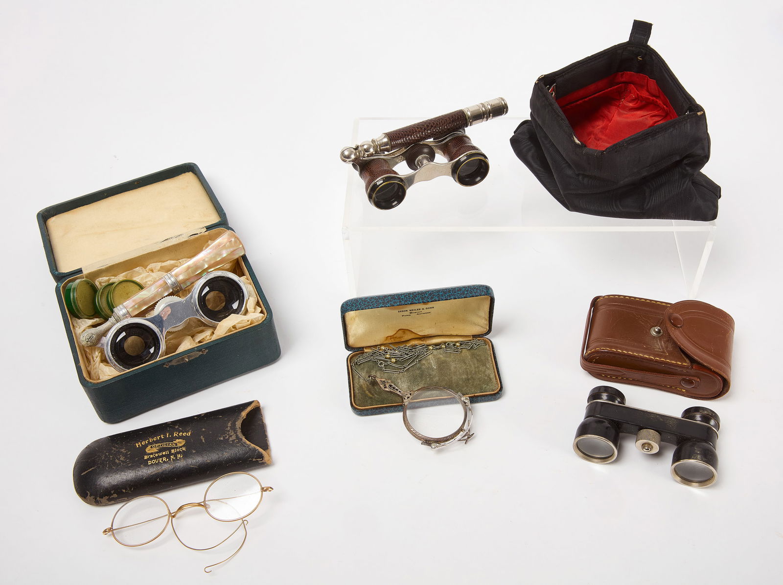 Group of Opera Glasses: Group of 3 opera glasses, a regular pair of glasses, and a lorgnette. One pair of opera glasses are black, 2.5x, and stamped 'Banks' and 'Tokyo'. They come within a brown lea