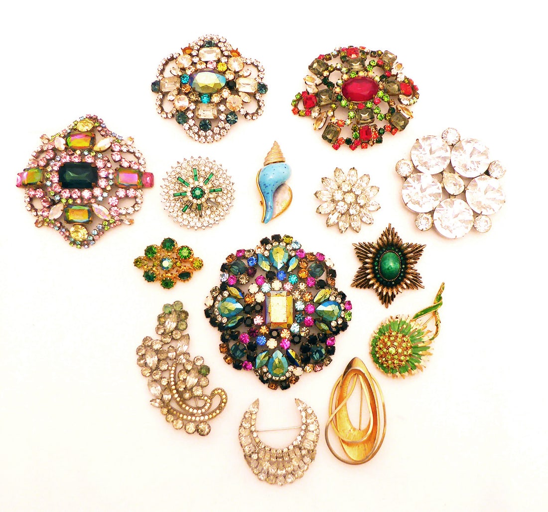 Mixed Group of Fourteen Vintage Brooches: Mixed group of 14 vintage costume brooches. Brooches are silver or gold colored with plastic and glass stones in a variety of colors. Brooches are signed by different designers including Weiss, Orene,