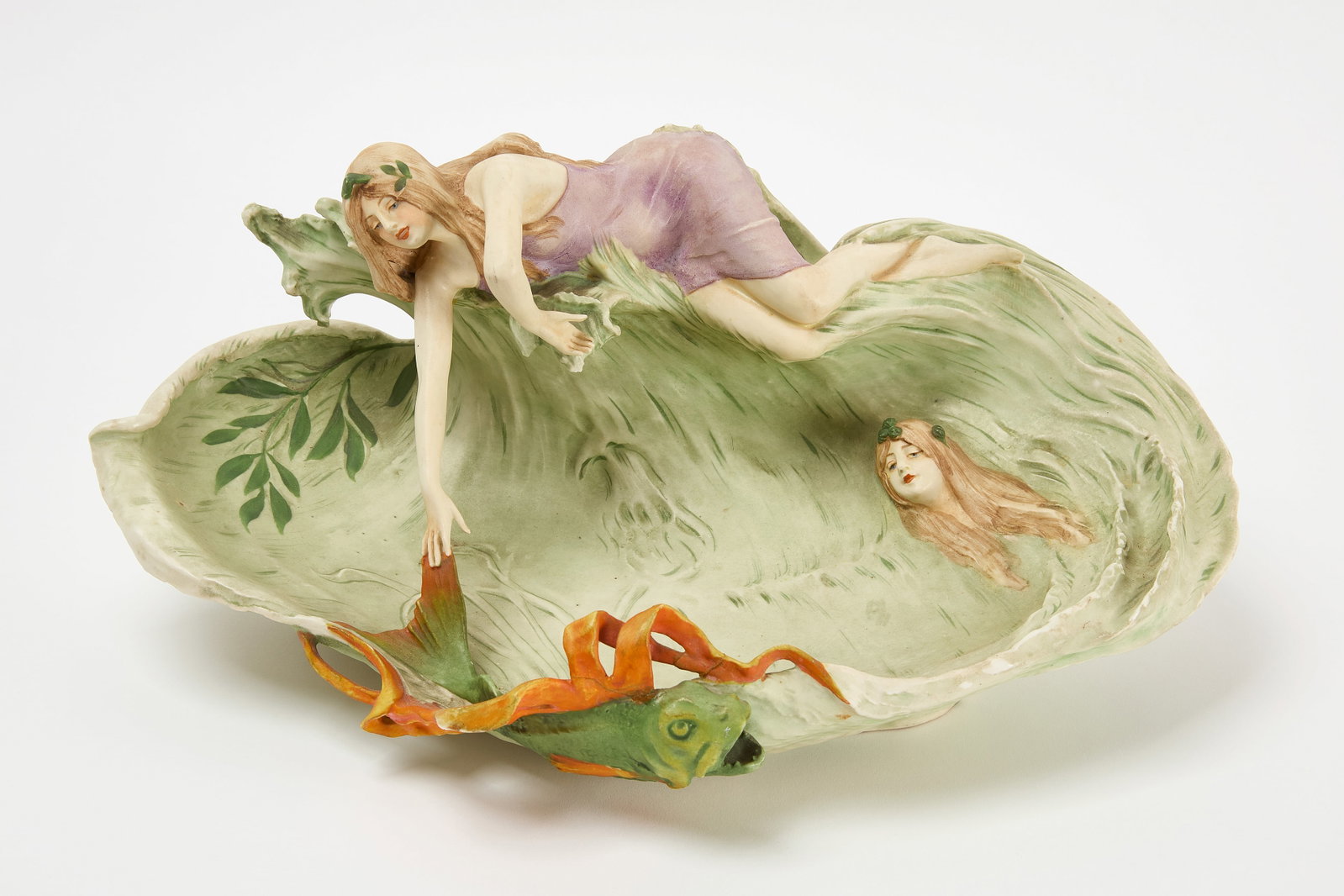 Art Nouveau Dish - Lady with Koi: Art nouveau dish in porcelain depicting a lady touching the tail of a large koi fish. H 8 in. W 17-1/4 in. D 10-1/2 in. Condition: Minor wear and imperfections. 