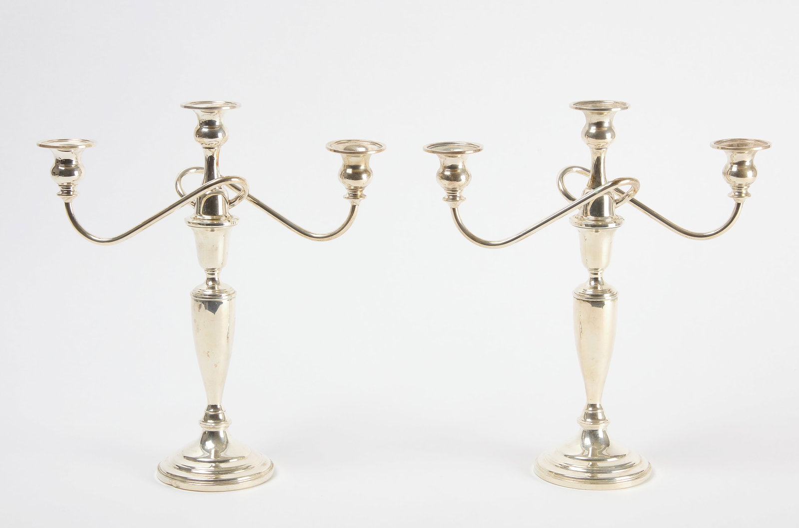 Pair of Sterling Reinforced Candelabra: Pair of sterling reinforced candelabra. Adjustable for either single candle or three candles. Circa 1920-30. H 13-1/4 in. W 11-3/4 in. Condition: Excellent original condition; usable.