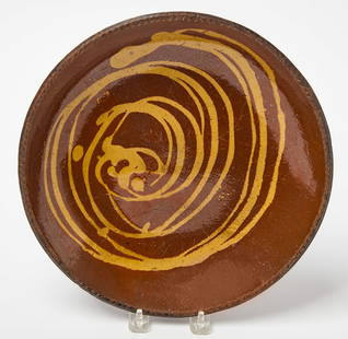 American Redware Plate: Deep redware plate with yellow abstract spiral design. Pennsylvania, circa 1850. D 11-1/4". Condition: Original condition. Tight crack extending about 6" from the rim. Otherwise,