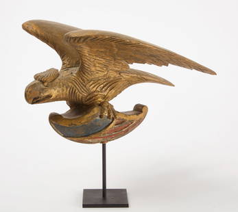 Carved Eagle with Shield: Carved eagle&nbsp;with shield. Wood with original paint. Likely Maine, circa 1875. H 12 in. (inc stand)&nbsp;W 12-1/2 in. Condition: Original condition with minor surface imperfections. Stand included