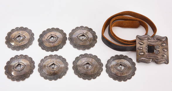 Antique Navajo Concho Silver Belt: Navajo leather belt with silver buckle and seven silver conchos, all with stamping. American, early to mid 20th century. Belt: L 35 in. Buckle H 2-3/4 in. W 3-1/4 in. Conchos: H 3 in. W 2-1/2 in. Tota