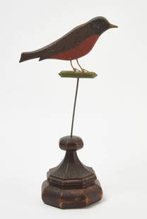 Folk Art Bird Sculpture: Folk art bird sculpture. Painted wooden figure with wire legs and stand atop a finial base. Depicting a perched robin. American, early to mid 20th century. H 16 in. W 8 in. D 5-1/2&nbsp;in. Condition: