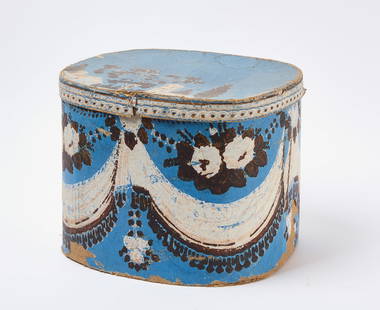 Wallpaper Hat Box: Wallpaper hat box in oval form. Blue with white castles and trees. American, mid to late 19th century. H 11-1/2 in. W 15 in. D 12-1/2 in. Condition: Wear, losses, and imperfections. Link to high-res i