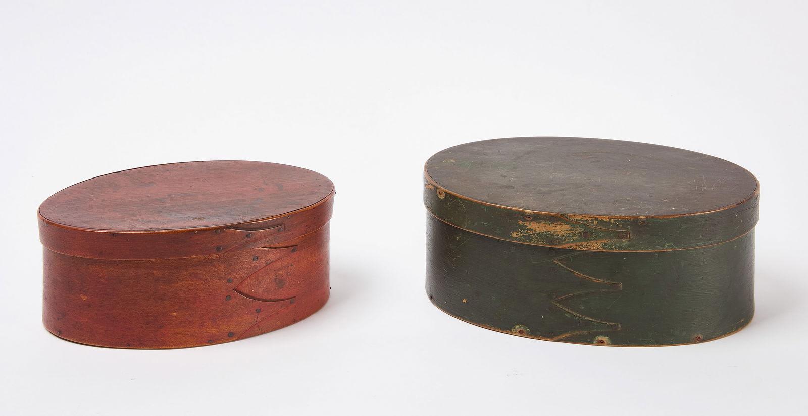 Two Shaker Oval Boxes in Paint: Two oval Shaker boxes. Smaller in red paint, larger in green paint. New England, late 19th century. H 3-1/2 in. W 9 in. D 6-1/4 in. H 4 in. W 10-1/4 in. D 7-1/4 in.