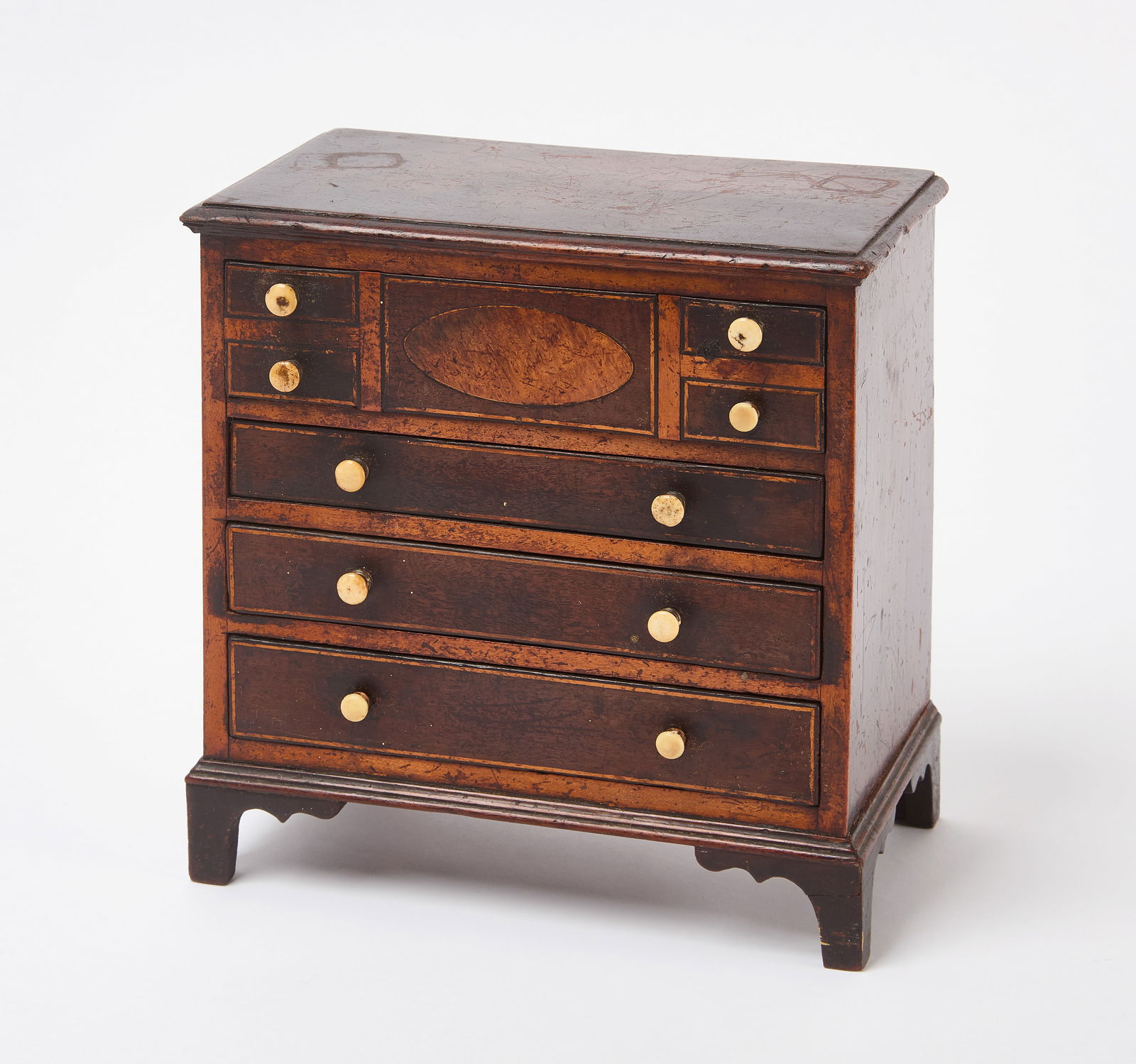 Miniature Sheraton Four-Drawer Dresser: Miniature Sheraton 4-drawer dresser. Satinwood inlay with bone pulls. English, circa 1800. H 8-3/4 in. W 8-1/4 in. D 4-3/4 in.