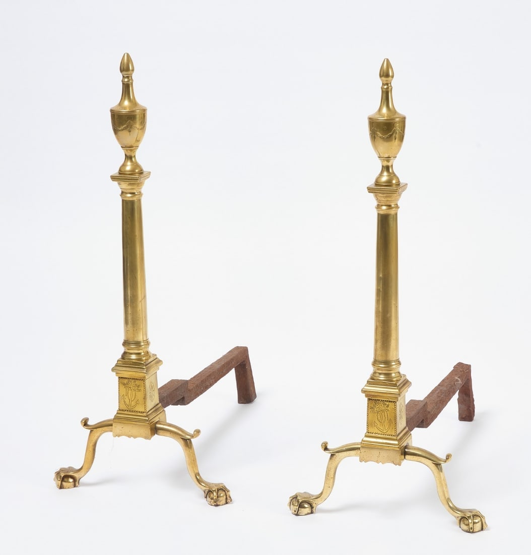 Pair of Early Brass Engraved Andirons: Pair of early andirons with ball and claw feet. Urn-form finial inscribed with swag, lower portion with front anchor engravings and side cartouche engravings. Brass with wrought iron supports. E