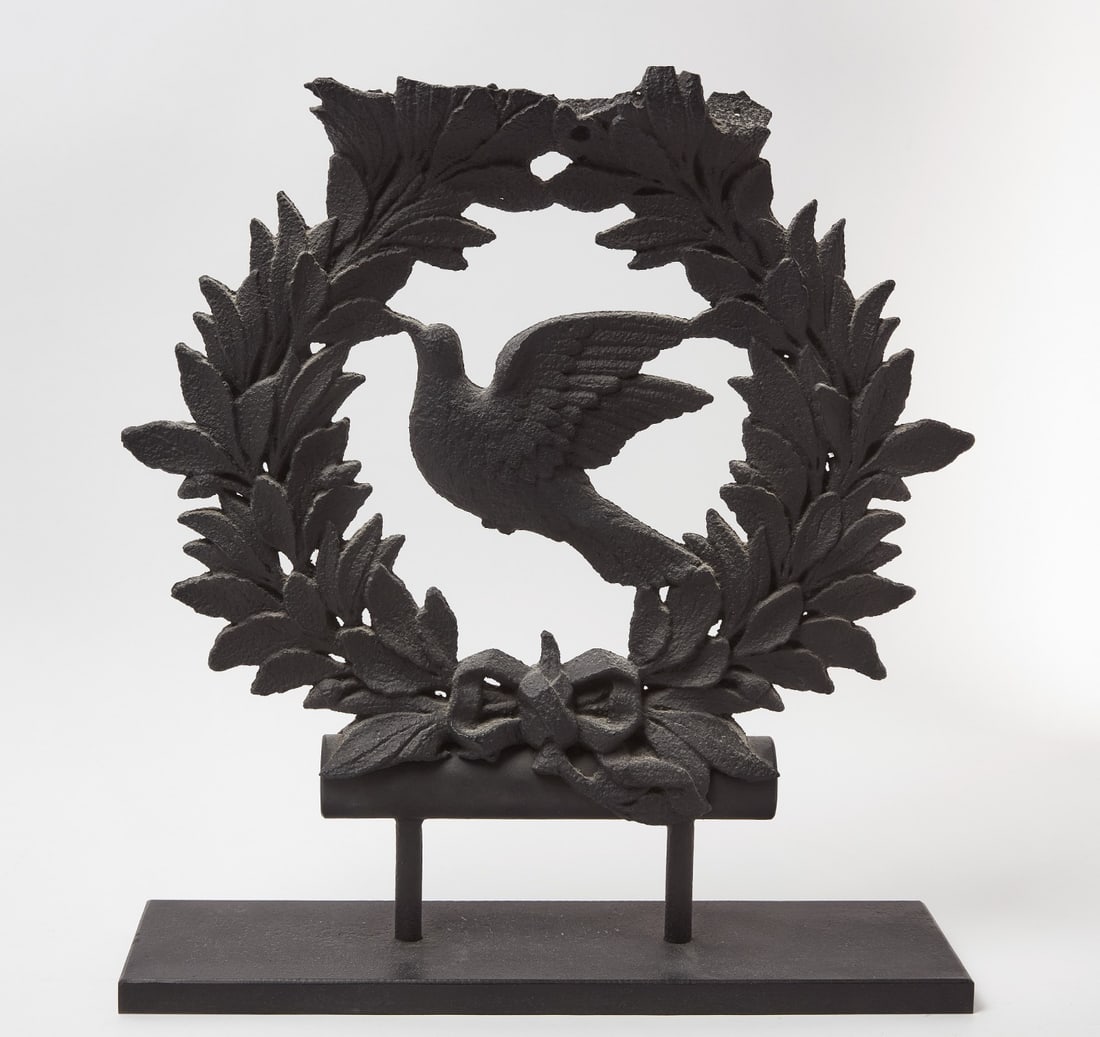 Cast Iron Industrial Dove and Wreath: Industrial or architectural element of a dove in a wreath. Cast iron in old black paint. American, 19th century. Mounted to custom stand. Provenance: Collection of Sally and William Gemmill. Overall:
