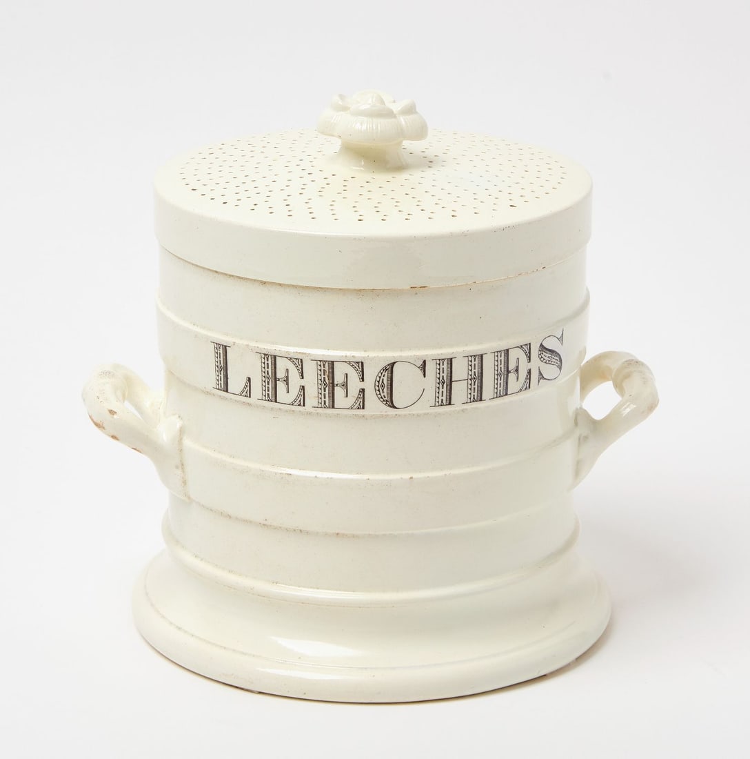 Handled Leeches Jar: Handled apothecary 'Leeches' jar. Earthenware with printed stylized lettering. Flower finial on lid. English, 19th century.H 9-1/4 in. W 9-3/4 in.Provenance: Estate of Jerry Phelps (Kentucky,