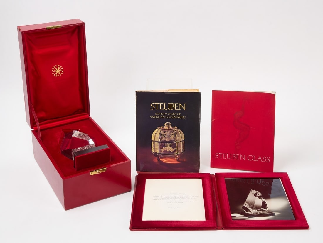 Steuben Glass Pyramidon: Steuben Glass Pyramidon designed by George Thompson. Crystal form rising to a point, the sides cut in flat, irregular facets. Textured base, pebbled with glass chips. Rests on a rotatable black stand.