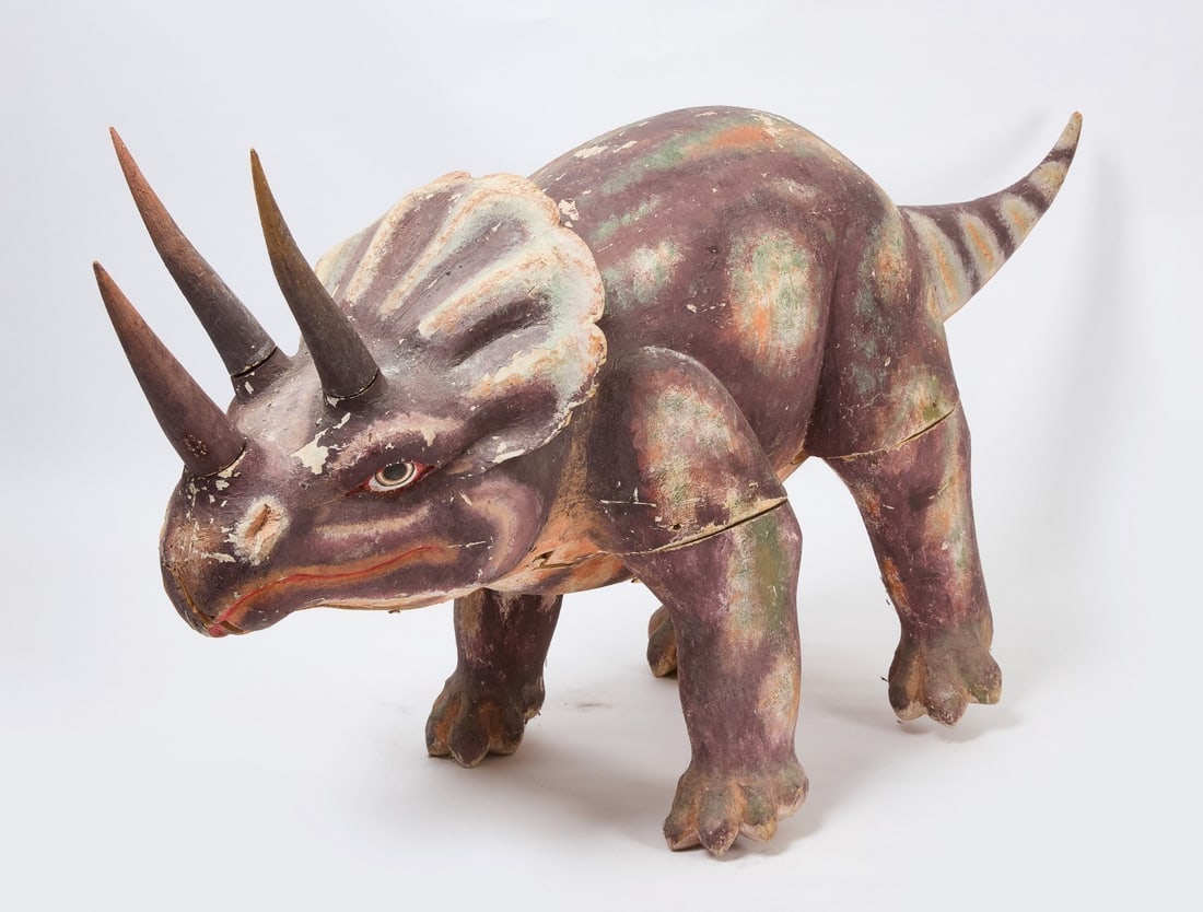 Folk Art Carved and Painted Triceratops: Folk art carved Triceratops in green, purple, white, and orange paint. Removable horns and tail. American, early 20th century.H 36 in. L 82 in. W 21 in.