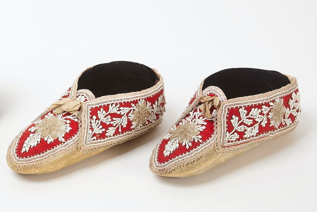 Pair of Seneca Moccasins: Pair of Seneca moccasins. White beads on red cloth. Circa 1870. White beads: L 9 in.