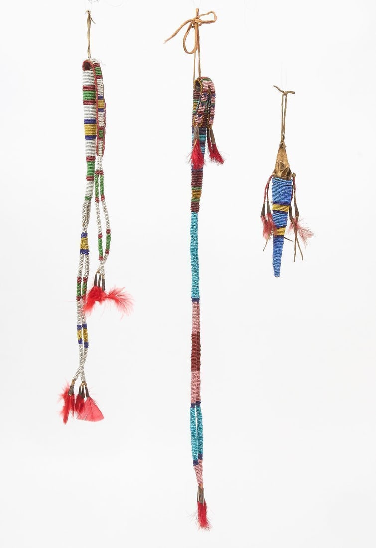 Three Beaded Awl Cases: Three awl cases. Beadwork on hide with tin cones. Smallest with bone awl. Plains regiom, circa 1900.L 18 in, 22 in. 7 in.