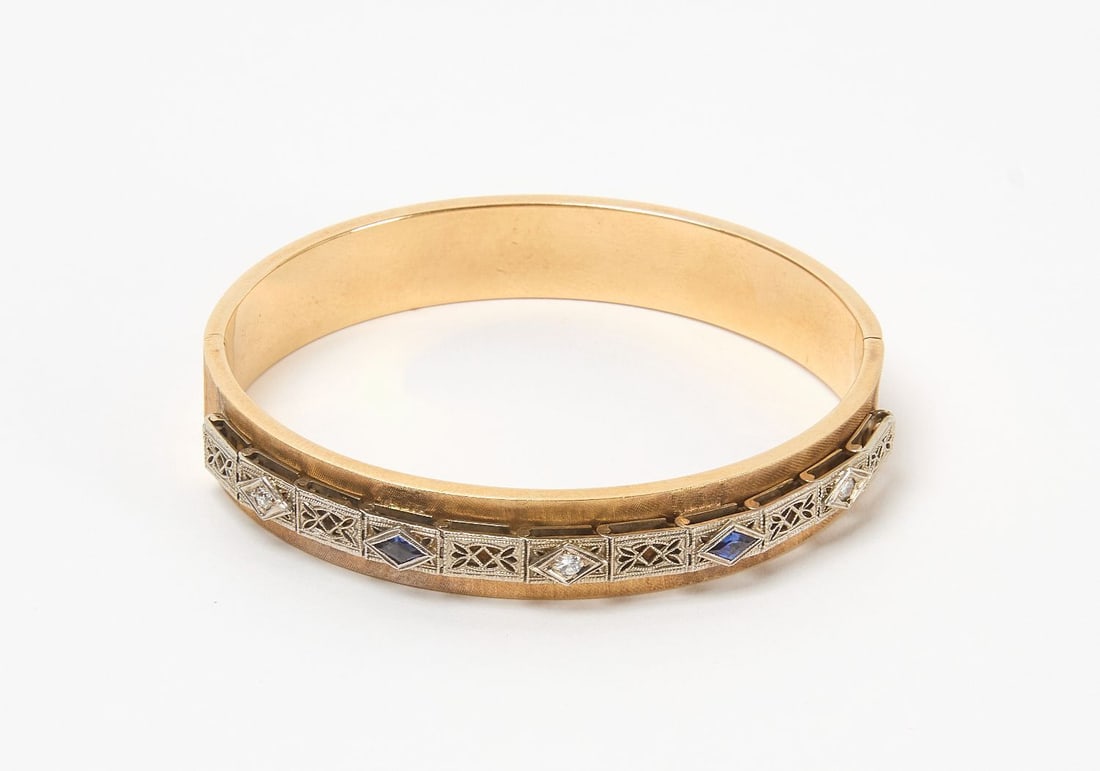 14k Diamond and Sapphire Art Deco Bracelet: 14k (stamped) yellow gold diamond and sapphire art deco bangle bracelet. Total Weight: 13 dwt. Outer: W 2-9/16 in. L 2-5/16 in. Inner: W 2-3/8 in. L 2-1/8 in. 