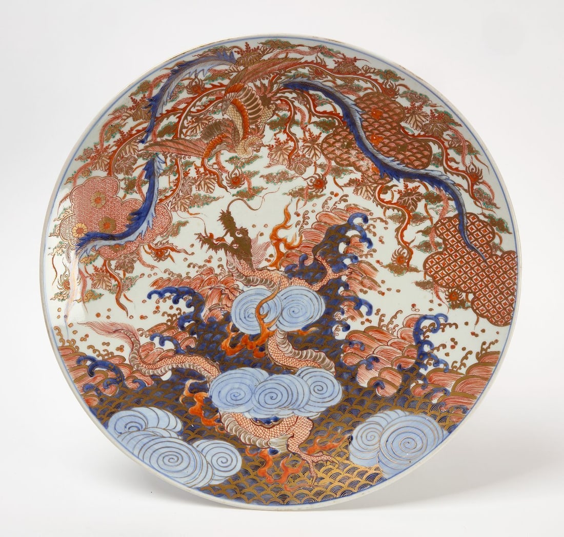 Large Imari Charger with Dragon: Large Imari porcelain charger. Decorated with dragon and cloud motifs in underglaze blue, iron red, and gilt. Japanese, late 19th century.Dia. 18-1/8 in.