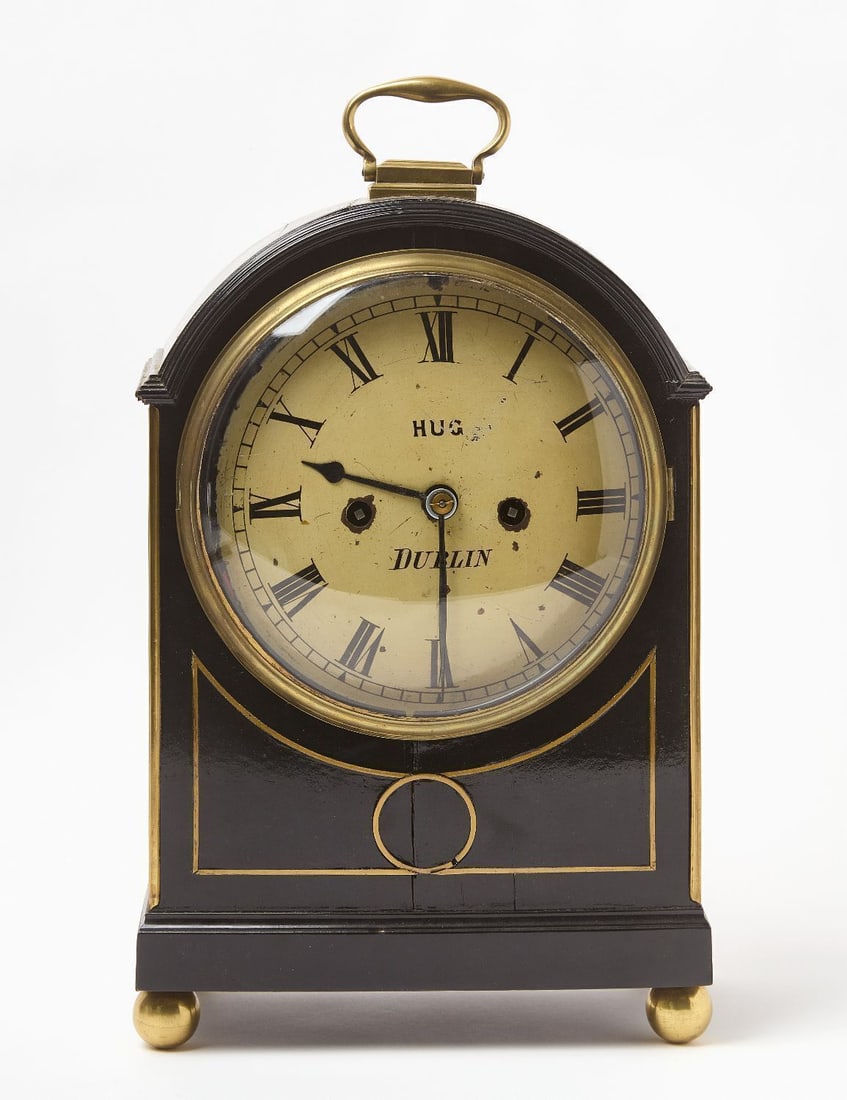 Dublin Mantel Clock with Fusee Movement: Dublin mantel clock with fusee movement. Ebonized wood case with brass hardware and ball feet. Pendulum and key included. Ireland, circa 1910. H 16 in. W 10-1/2 in. D 6 in.