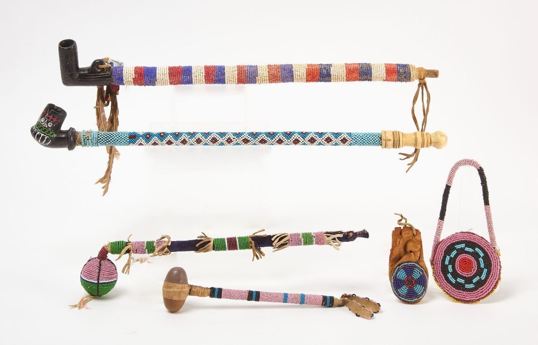 Group of Beaded Objects: Group of beaded objects. Including; two small hide pouches, two carved catlinite pipe with beaded pipe stem, a beaded hammer and a beaded drum beater. Circa 1920-40.Pipe: L 18-5/6 in. Hammer L