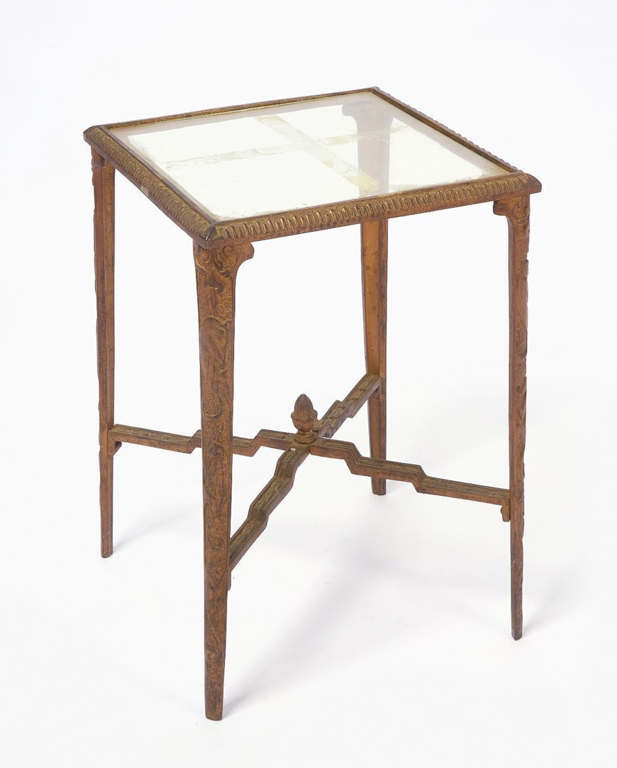 Art Deco Side Table: Art deco side table. Bronze with stepped crossed supports with central finial, sides with monkey motifs. Glass top. circa 1930. H 19-1/2 in. W 13-3/4 in. D 13-3/4 in.