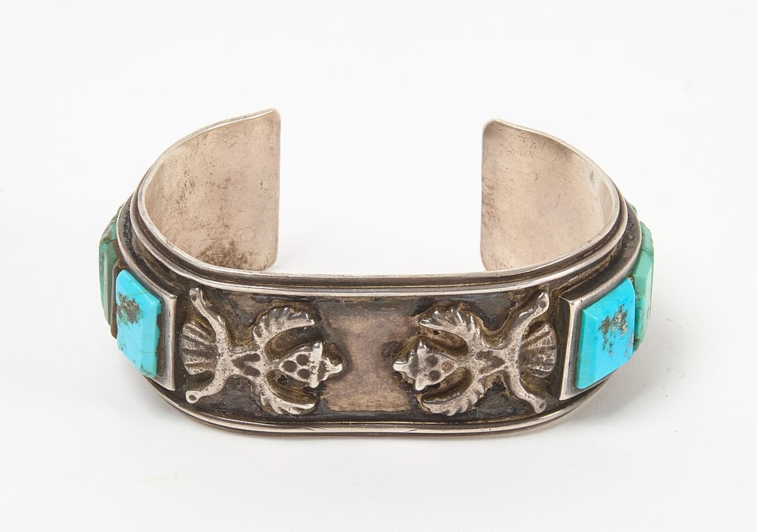 Native American Bird Man Cuff Bracelet: Native American 'bird man' cuff bracelet with inset turquoise stones. Signed with initials 'WE' on backside. Southwestern US, 20th century. Total Weight: 2.435 ozt. Outer W: 3 in.,