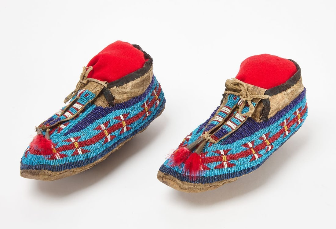 Pair of Beaded Moccasins: Pair of beaded moccasins. Glass beads on hide. Sinew sewn. Plains area, circa 1890. L 10 in.
