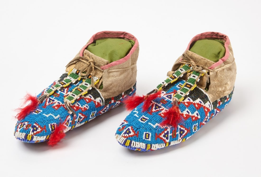 Pair of Ceremonial Fully Beaded Moccasins: Pair of ceremonial fully beaded moccasins with beaded bottoms. Glass beads on hide. Sinew sewn. Plains region, circa 1900. L 9-1/2 in.