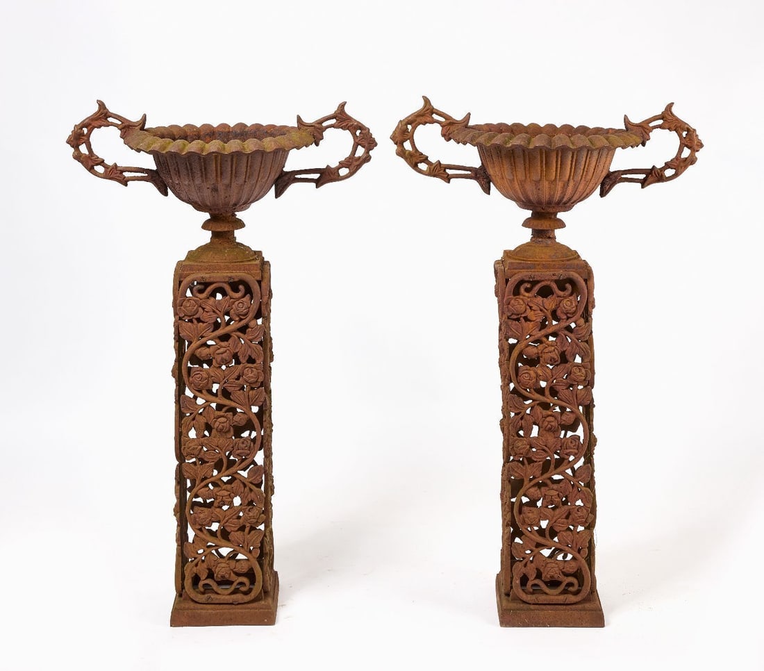 Pair of Floral Pedestal Garden Urns: Pair of garden urns on tall, floral rectangular pedestals. Cast iron. Continental, circa 1900. H 44-5/8 in. W 27-1/2 in. D 16-1/2 in.