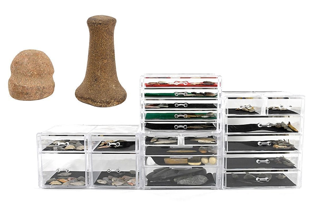 Collection of Native American Lithics and Two Stone Pounders: Collection of Native American Lithics, housed in pictured storage containers (included); together with two stone mashers one grooved and one pestle-shaped. Largest (box): H 11 in. W 9-1/2 in. D