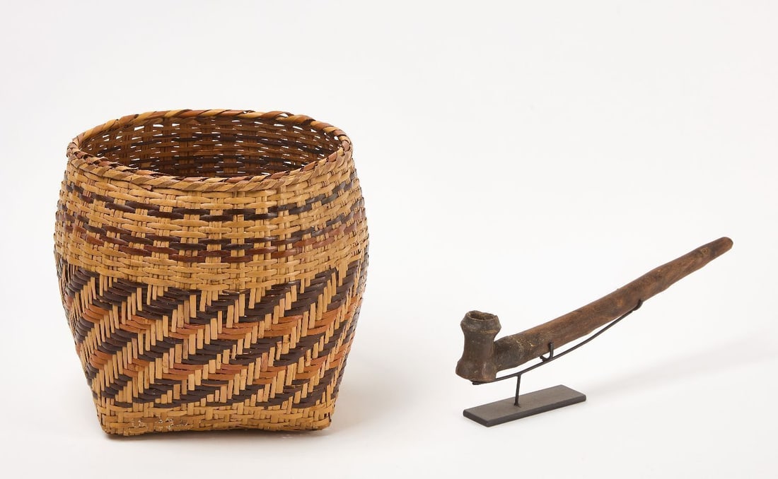 Early Cherokee Pipe and Basket: One early Cherokee pottery pipe with Cherokee basket. Stone pipe with wood stem. Cherokee Nation, Oklahoma, circa 1900, (pipe likely earlier). H 2-1/2 in. L 15 in. H 10-1/2 in. 12 in.