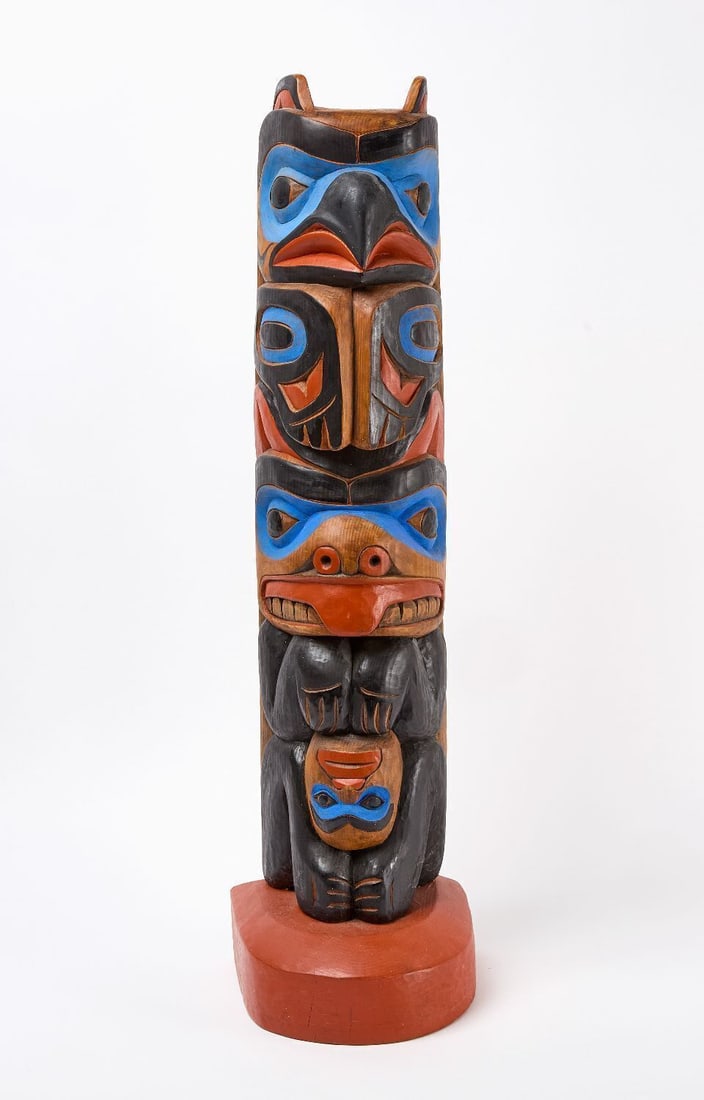Rich Lavalle Painted Totem: Large carved cedar totem painted in black, blue, and red polychrome paint. Wood base. Signed on back 'Lavalle'. Mid to late 20th century. H 33-1/4 in. W 8-3/4 in. D 8-1/2 in.